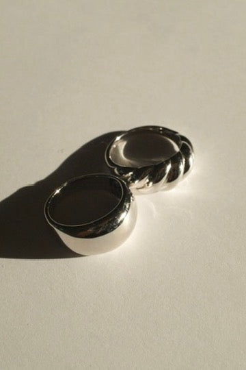 Two silver rings on a light gray surface